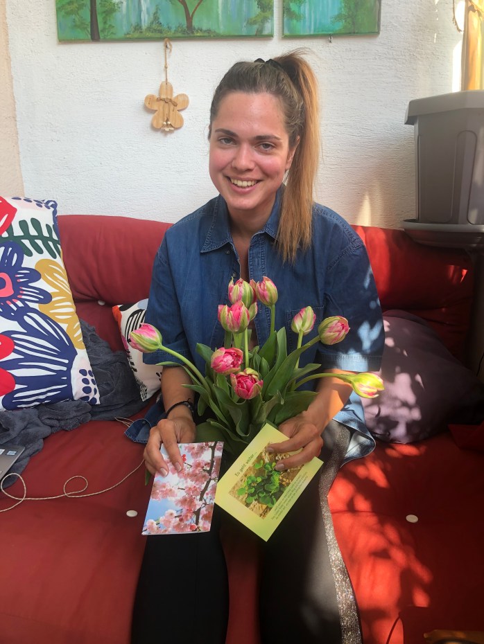 Junge Frau mit Blumen und Karten mit Genesungswünschen